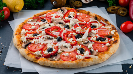 Italian pizza with mushrooms, tomatoes, sweet peppers, olives, onions and feta cheese.