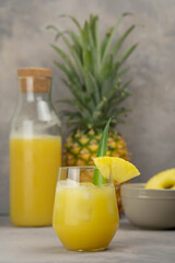 Pineapple cocktail in glass jars on wooden table closeup
