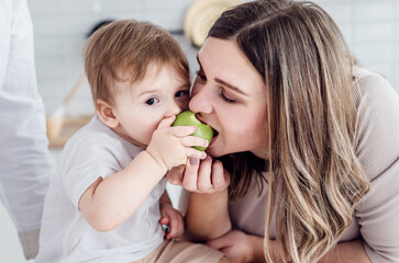 Mom and son bite one apple at the same time