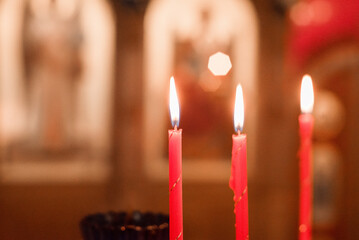 Group of burning church candles at blurred background.