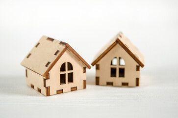 Two small wooden houses on white wooden background, the concept of family happiness, buying a house