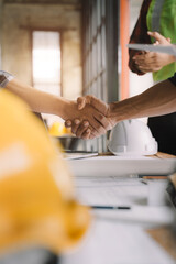 Obraz na płótnie Canvas Construction workers, architects and engineers shake hands while working for teamwork and cooperation after completing an agreement in an office facility, successful cooperation concept.