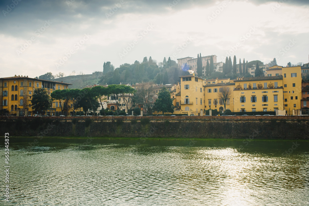 Wall mural view of the arno river in italy and the historic bridge with the reflection of beautiful colorful ho