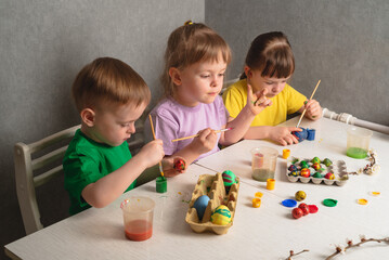 Naklejka premium Children color eggs with food coloring. Getting ready for Easter