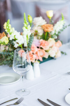Wine glass and dinnerware on table at wedding
