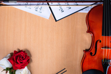 Recurso para anuncios musicales. Violin, partituras y rosas sobre la mesa	