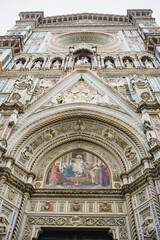 Fototapeta na wymiar Catholic Cathedral of Santa Maria del Fiore. Giotto's bell tower. Reliefs and frescoes on marble walls. Renaissance Era