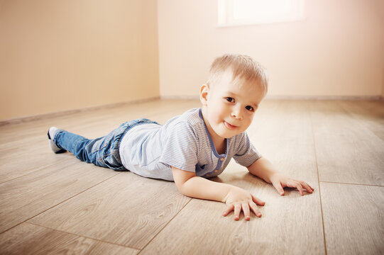 Portrait of the cute boy lying on the floor indoor.