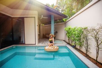 A woman lounging in a tropical villa swimming pool