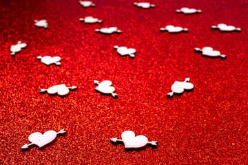 Valentines day background. Cupid's arrows over hearts. Red glitter love background.