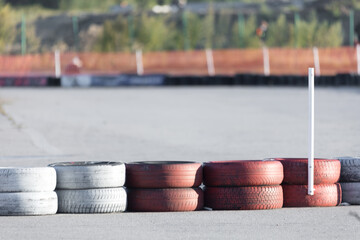 Tire barriers on asphalt along karting track - obrazy, fototapety, plakaty