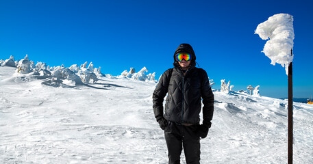 Fototapeta na wymiar Young man in the winter mountains. Winter sports. Mountain landscape. Skiing and mountain climbing.