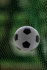 Soccer ball in goal net, close-up. football background