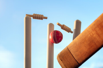 Cricket ball hitting wicket stumps knocking bails out - obrazy, fototapety, plakaty
