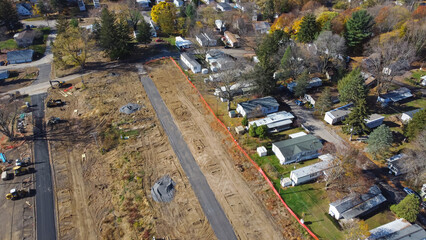 Aerial view construction site of mobile trailer park near complete manufactured houses colorful fall foliage in Rochester, New York