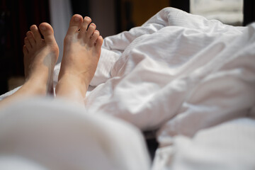 Obraz na płótnie Canvas Two leg of pretty girl on white bed.