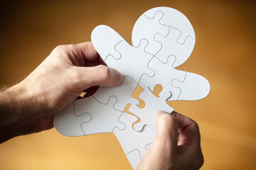 Businessman assembling missing jigsaw puzzle piece human team employee - 565363091