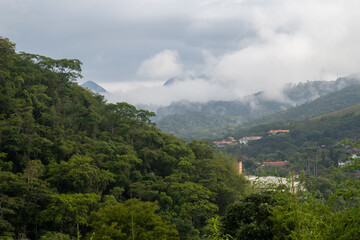 Obraz premium Houses built on the Atlantic Forest, on a foggy day, viewed form a neighborhood in Petropolis, RJ, Brazil