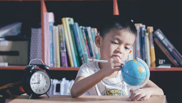 Little Boy Studying At Home With World Globe Looking Map Wold,Training Webinar E-learning Skills Learning Internet Technology Concept.SEO Search Engine And Kid Education.