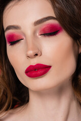 Obraz premium close up of young woman with magenta color makeup and closed eyes.