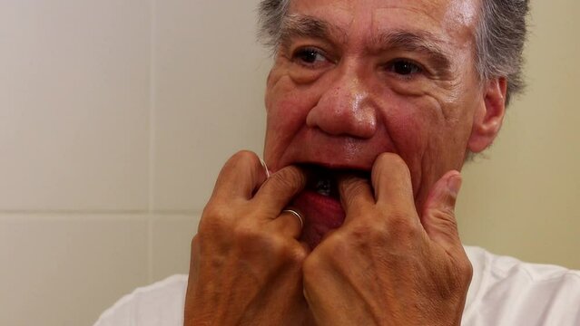 Senior man flossing his teeth with dental floss