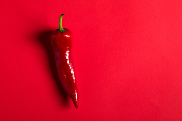 Red pepper on the red background.