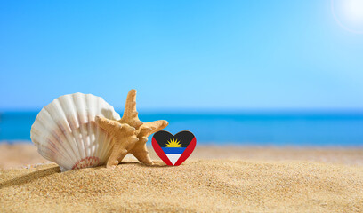 Beautiful beach in the Antigua and Barbuda. Flag of Antigua and Barbuda in the shape of a heart and...