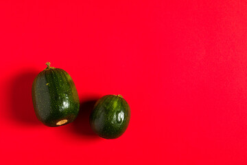 Vegetable marrow on the red backdrop.