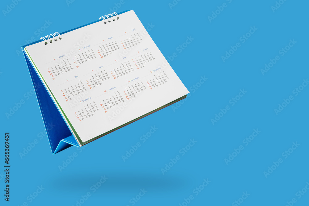 Wall mural white paper desk calendar flipping page isolated on blue background