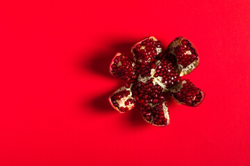 Peeled pomegranate on a red background.