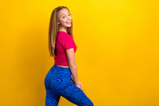 Photo of charming optimistic teen age positive woman wearing pink t-shirt blue pants behind cadre advert promo isolated on yellow color background