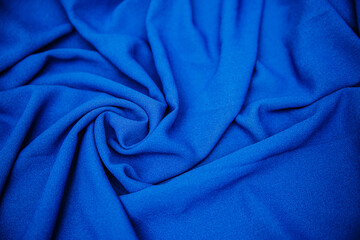 A folded blue cloth lies in folds on the table. Drapery texture. Synthetics