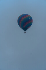 hot air balloon in a clear sky and between trees a balloon ride