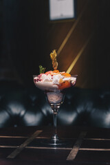 Delicious white dessert in a cocktail glass with a dark background