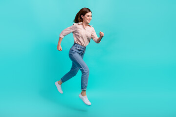 Fototapeta na wymiar Full length photo of funky excited girl dressed pink shirt jumping high hurrying isolated teal color background