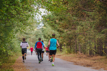 Obraz premium back group male runners running race in park