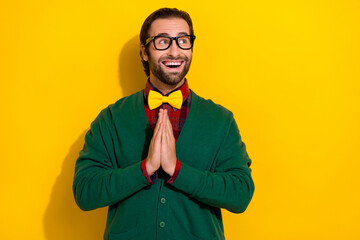Portrait of positive impressed man arms palms plead look empty space proposition isolated on yellow...