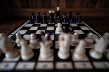 Blurred background with a low depth of focus. The set of wooden chess pieces elements standing on...