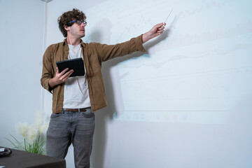 man holding tablet standing in front of conference room presenting stock trading, gaming, business,...