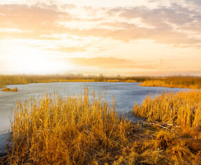 small frozen lake among prairie at the sunset