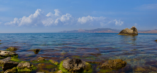 emerald sea bay with huge stones near a coast, summer sea vacation scene