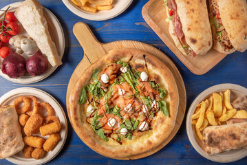 Composition of typical italian street food photographed from above in a blue wooden table 