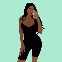 The girl poses and takes pictures of herself on the phone in the mirror after a workout in the gym