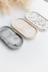 Handmade round concrete coasters with abstract creative terrazzo pattern. Granite shards. Colorful texture of stones and rocks. Neutral concrete terrazzo coasters. Recycled materials. Home Decor.