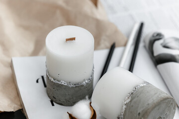Handmade wax and concrete candle with gilding on journal. Holiday Advent. Cozy atmosphere. 