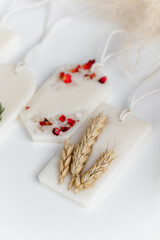 Aroma sachet with dried flowers with coconut or organic soy wax. Close up on white background