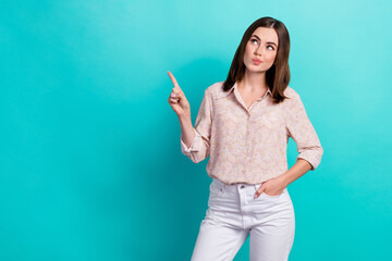 Photo portrait of nice young lady look skeptical empty space dressed stylish smart casual clothes isolated on aquamarine color background