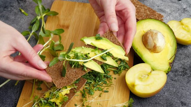 A woman cooks a breakfast of avocado and greens. the concept of healthy eating and veganuary