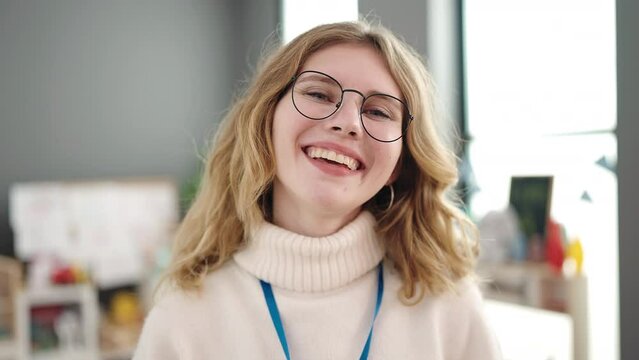 Young blonde woman preschool teacher smiling confident standing at kindergarten