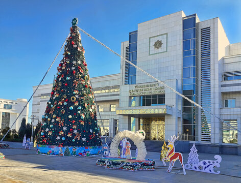 Ashgabat, Turkmenistan - January 07, 2022: Christmas tree on street of Ashgabat,  in the background the Ministry of Defense under the Ministry of Internal Affairs.